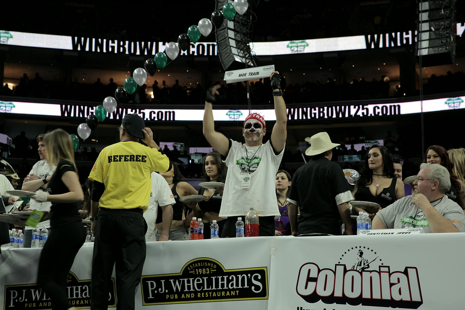 Moe Train holding his name sign overhead at the Wing Bowl 25 table, Wells Fargo Center